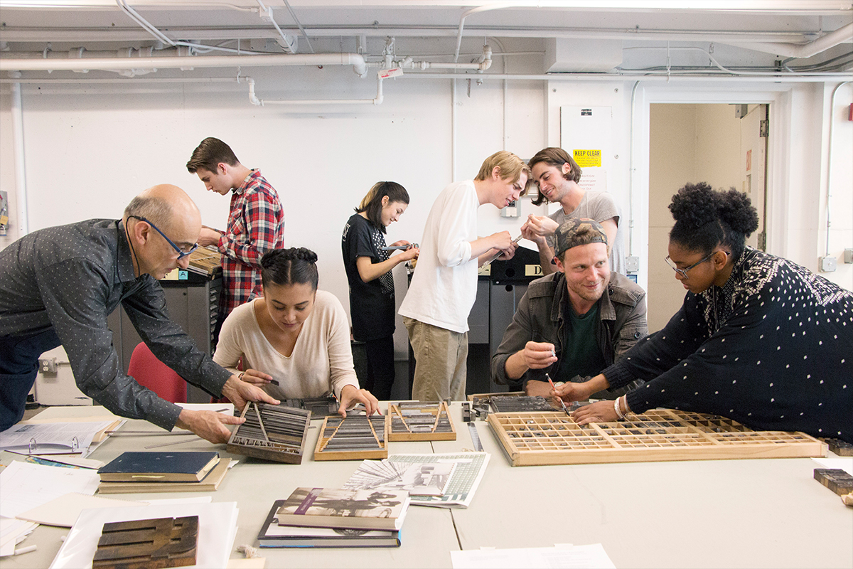 a class of students working with typography machine letter pieces 