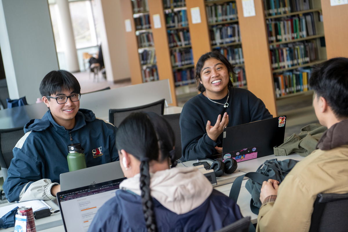 four students in a library studying